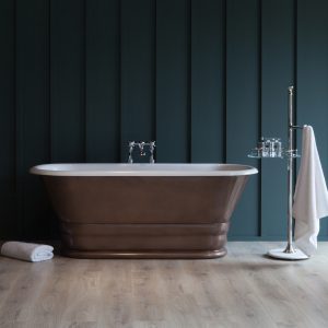 Luxury freestanding bathtub with a metallic finish set against a dark paneled wall, creating an elegant and modern bathroom aesthetic. Perfect for relaxing baths in stylish home interiors.