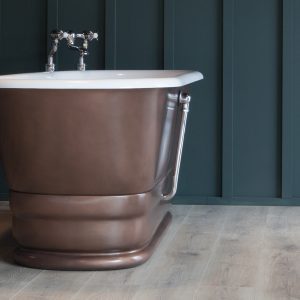 Elegant copper freestanding bathtub with traditional clawfoot design, chrome fixtures, and a modern backdrop, ideal for luxury bathrooms.