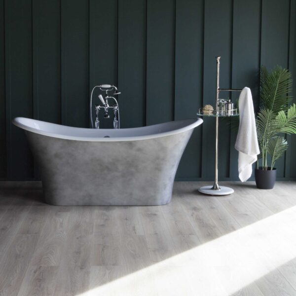 Sleek freestanding grey bathtub with vintage style chrome fixtures, set against dark green panel wall, complemented by a side trolly and potted plant, ideal for luxurious bathroom renovation.