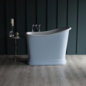 Classic freestanding bathtub with vintage-style chrome fixtures against dark wall paneling, complemented by a side table with candles and decor, perfect for a luxurious bathroom setting.