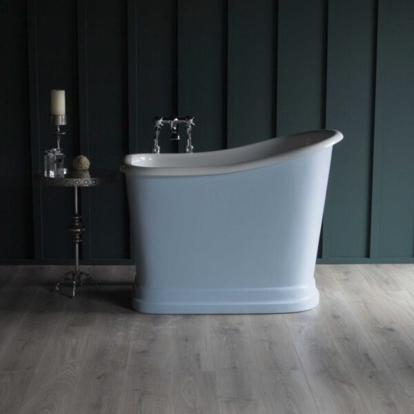 Classic freestanding bathtub with vintage-style chrome fixtures against dark wall paneling, complemented by a side table with candles and decor, perfect for a luxurious bathroom setting.