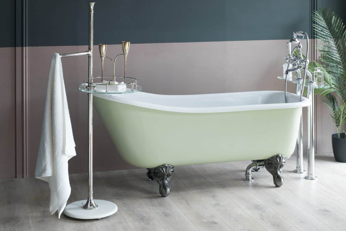 Vintage clawfoot bathtub with chrome fixtures and elegant accessories in a stylish bathroom setting.
