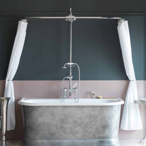 Elegant freestanding roll-top bathtub with chrome fixtures in a modern bathroom setting, featuring stylish curtains and contemporary decor, perfect for luxurious bathing experiences.
