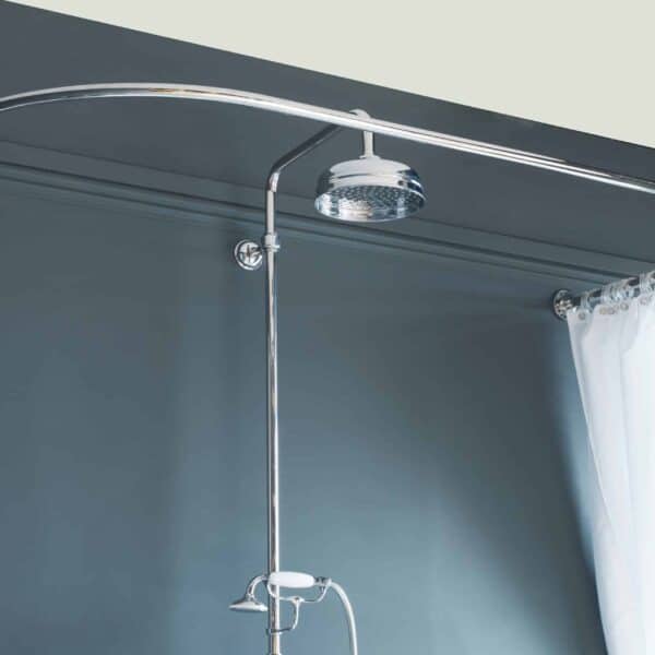 Elegant chrome shower system with curved shower bar, rainfall showerhead, and white shower curtains for a luxurious bathroom.