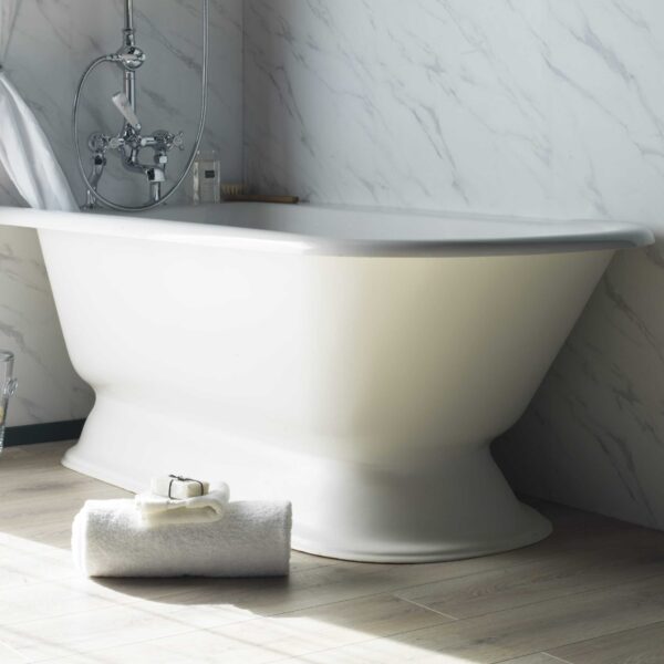 Elegant white freestanding bathtub with chrome fixtures, set against a marble wall in a luxurious bathroom, perfect for relaxation and styled with premium bathroom fixtures from Albion Bath Co Ltd.